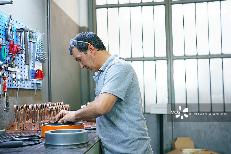 在工作台上使用工具的工人图片素材