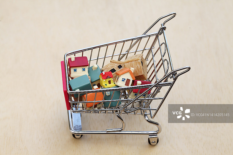 迷你购物车中的微型房屋模型图片素材