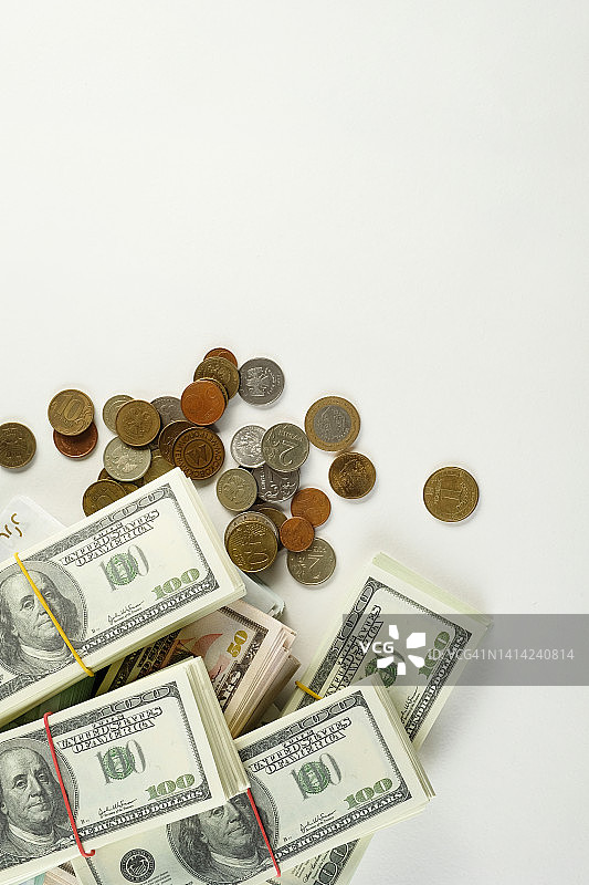 美元和欧元，欧盟和美国纸币捆在白色背景上。来自不同国家的硬币。工资，贿赂，利润或信贷资金。商业和金融，经济学，保险，投资和资金积累的概念。图片素材