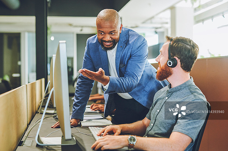 办公室技术支持人员指导同事。呼叫中心客服帮助解决在线客户服务问题。图片素材