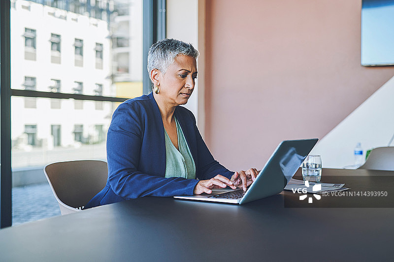 经理、老板或高级主管在办公室办公桌前使用笔记本电脑工作图片素材