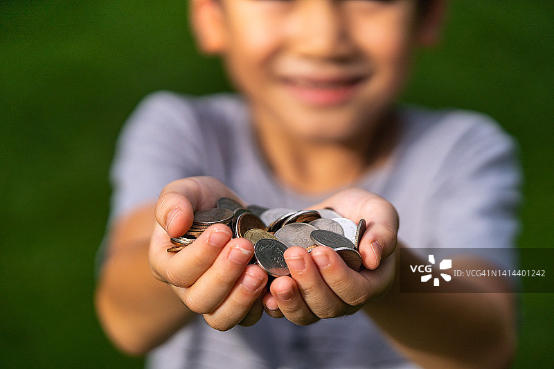 男孩拿着硬币，赡养费概念，金钱图片素材
