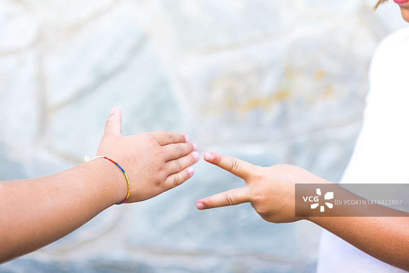 姐妹和朋友玩石头剪刀布的细节，夏季玩乐概念图片素材