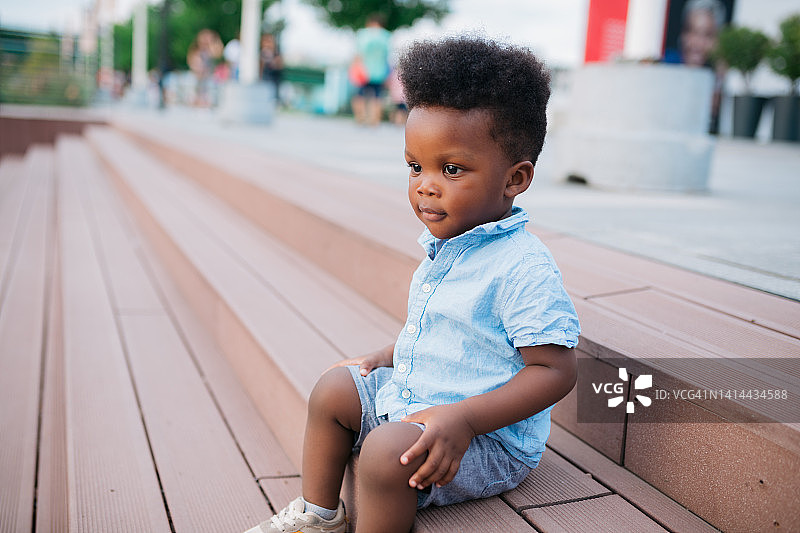 小男孩坐在户外的台阶上图片素材