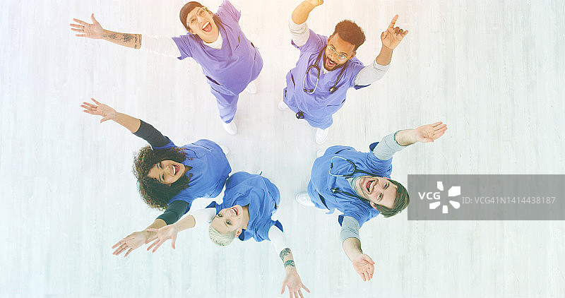 一群护士举起手臂庆祝好消息。关怀的医护人员对患者的积极更新感到高兴。医疗人员对良好的反馈感到兴奋。图片素材