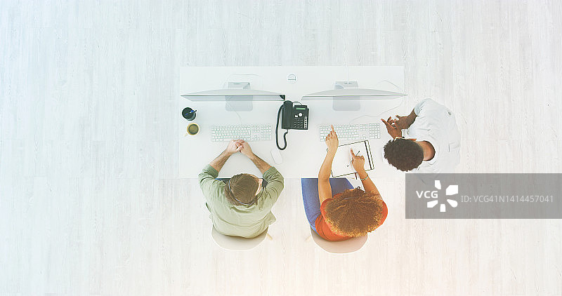 年轻的创意团队围坐在桌旁，共同商议业务计划图片素材