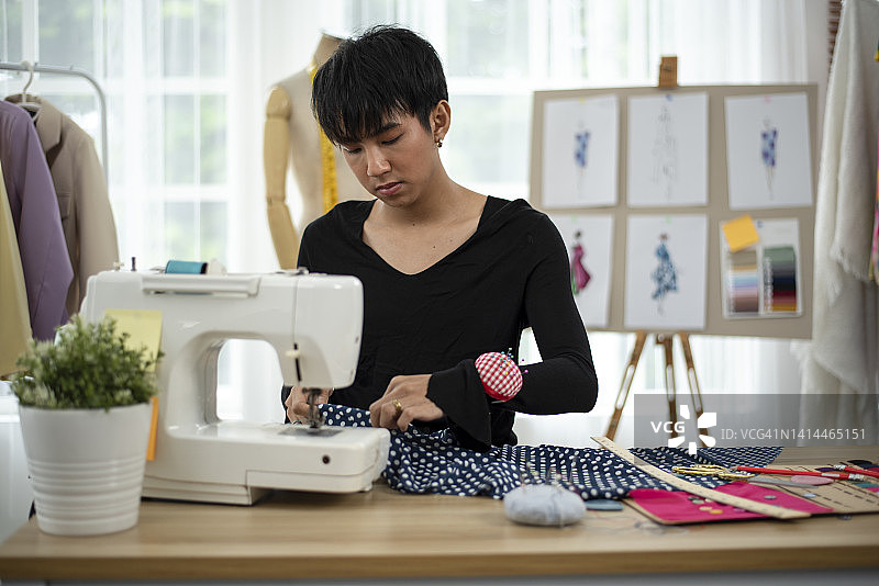 男装设计师使用缝纫机缝制服装图片素材