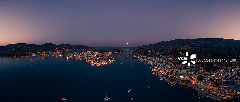 日落时分希腊伯罗奔尼撒Argosaronikos群岛的波罗斯岛和Galatas港口的航拍全景照片图片素材