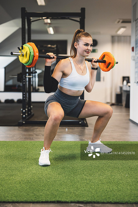 用杠铃做深蹲的女人图片素材