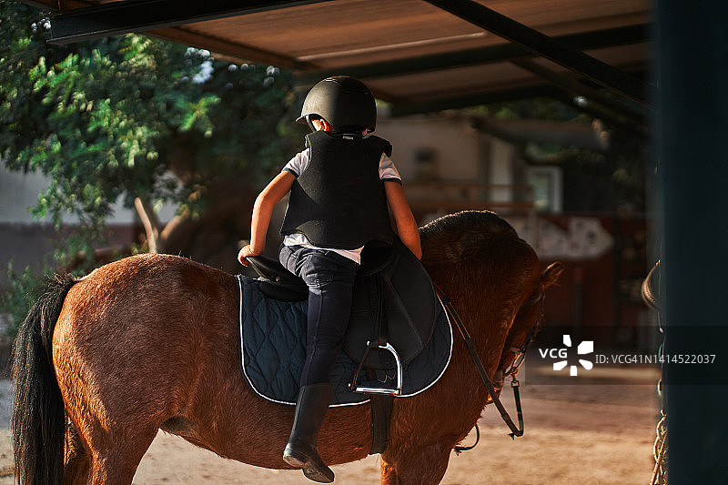 坐在马背上的匿名男孩图片素材