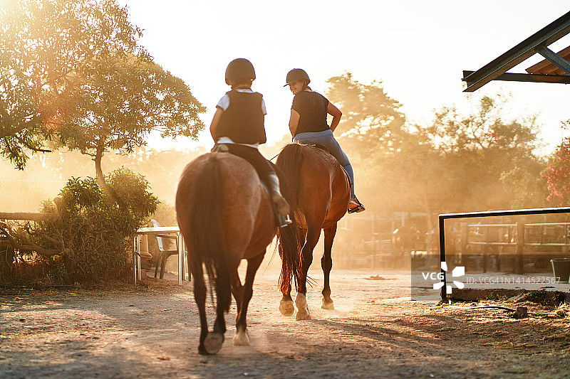 母子在日落时分骑马图片素材