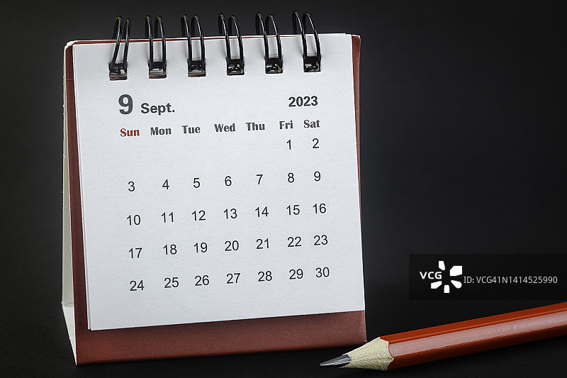 2023年9月是组织者计划的月份，红铅笔黑色背景。图片素材