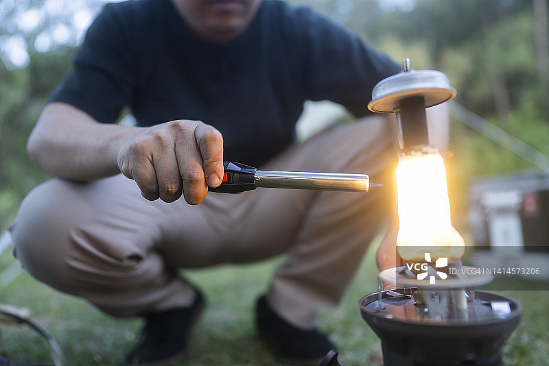亚洲年轻露营者准备煤油灯露营活动面部表情图片素材