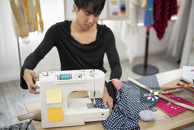 他专注于在家缝制衣服。图片素材