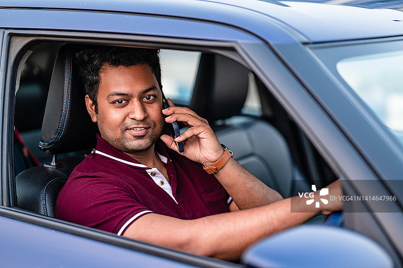 青年男子在城市街道驾车时使用手机图片素材