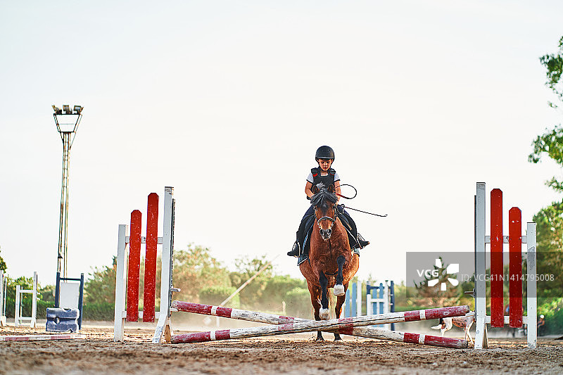 男孩骑马跳跃障碍图片素材