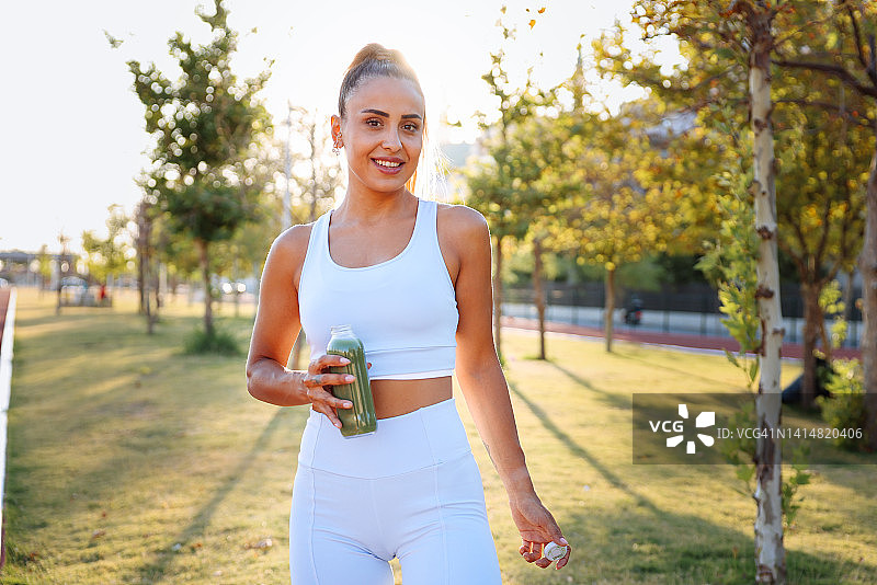 健身跑步后喝蔬菜冰沙的女人图片素材