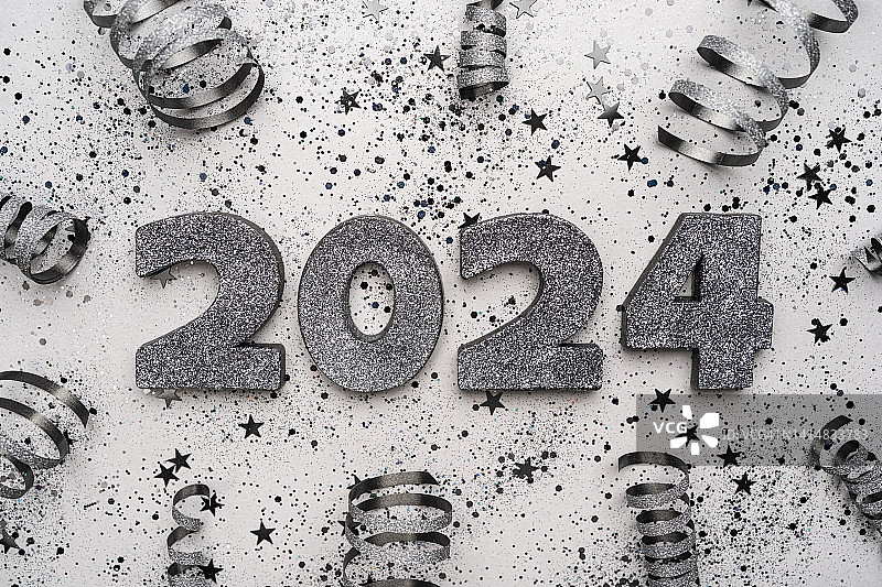 银色纸屑框架中的闪耀2024数字，灰色背景，节日新年背景，扁平风格图片素材