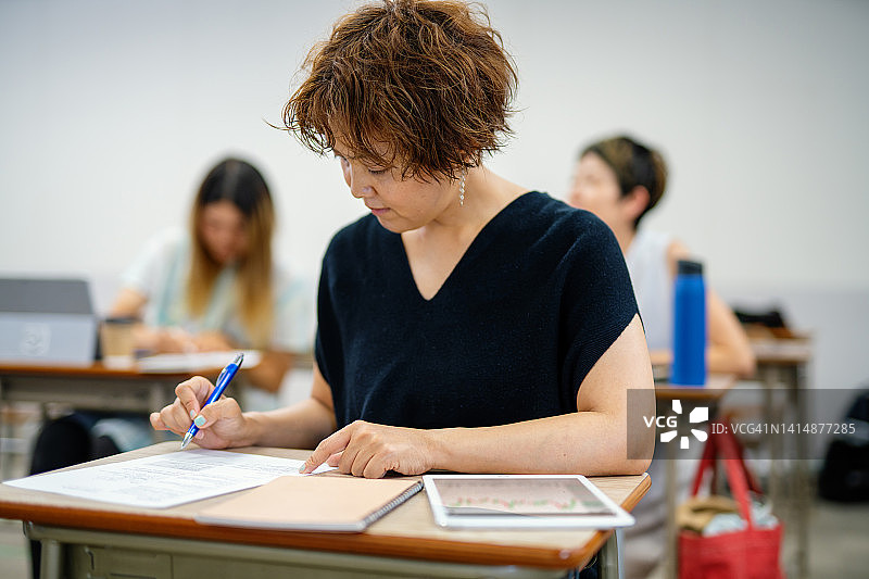 中年妇女在社区学院或大学的进修班上课图片素材