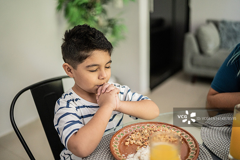 午餐前，小男孩在家祈祷图片素材