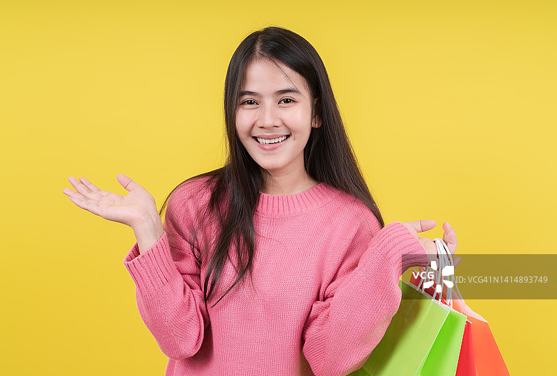 拿着购物袋的兴奋女孩肖像图片素材