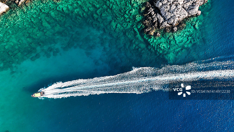 夏季在地中海开放海域航行的豪华快艇，夏季在地中海沿岸的游艇，夏季的地中海海滨，沿地中海多岩石山脉海岸线航行的游轮快艇图片素材