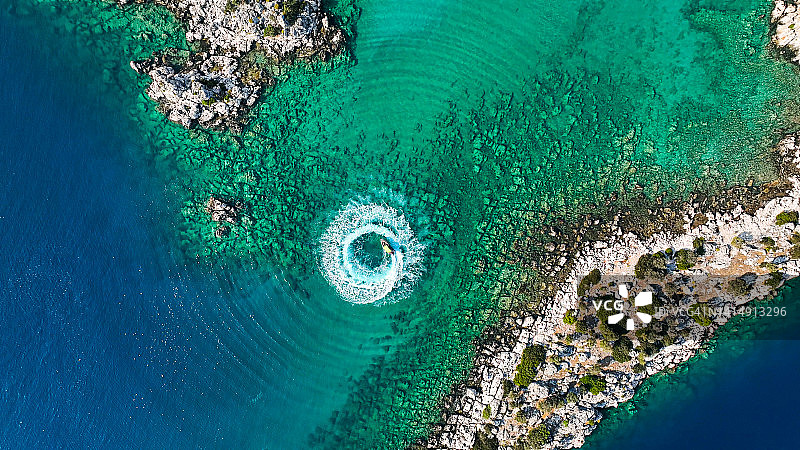 航拍：男子在海中驾驶水上摩托艇，形成圆形图案图片素材