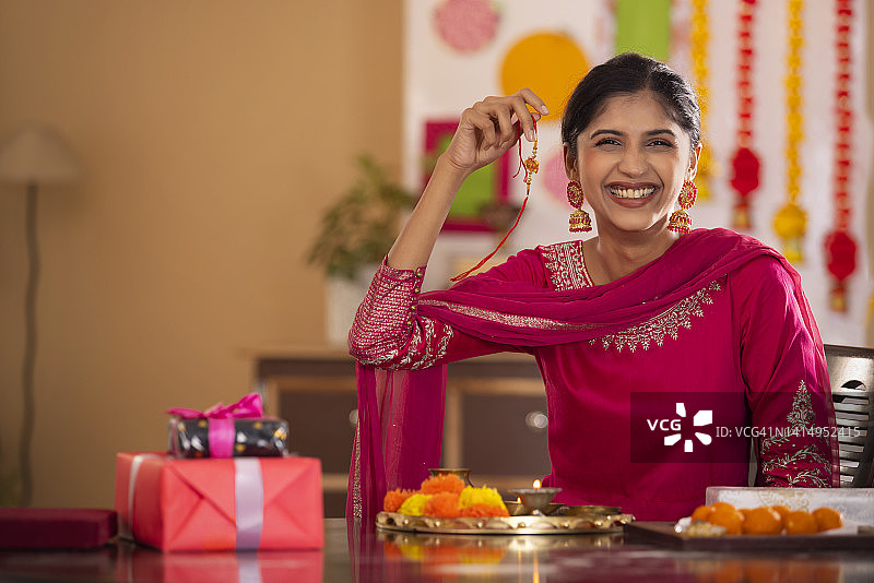 一位快乐的姐妹在拉卡沙·班丹节之际拿着拉其的肖像图片素材