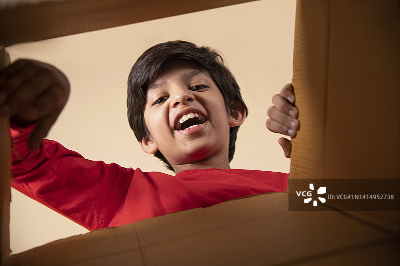 男孩打开纸箱的肖像照图片素材