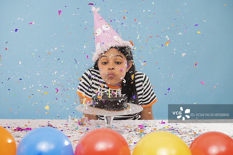 小女孩吹灭生日蜡烛肖像图片素材