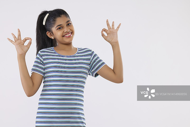 在白色背景下手势开朗的女孩的肖像图片素材