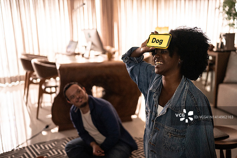 朋友们在家玩猜谜游戏，包括一位有特殊需求的人图片素材