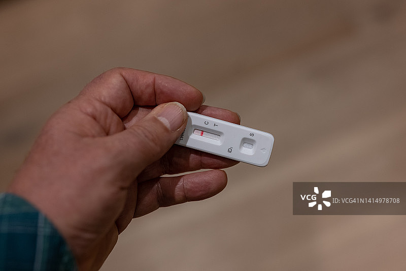 新冠病毒快速检测阴性结果：一名男子拿着测试盒图片素材