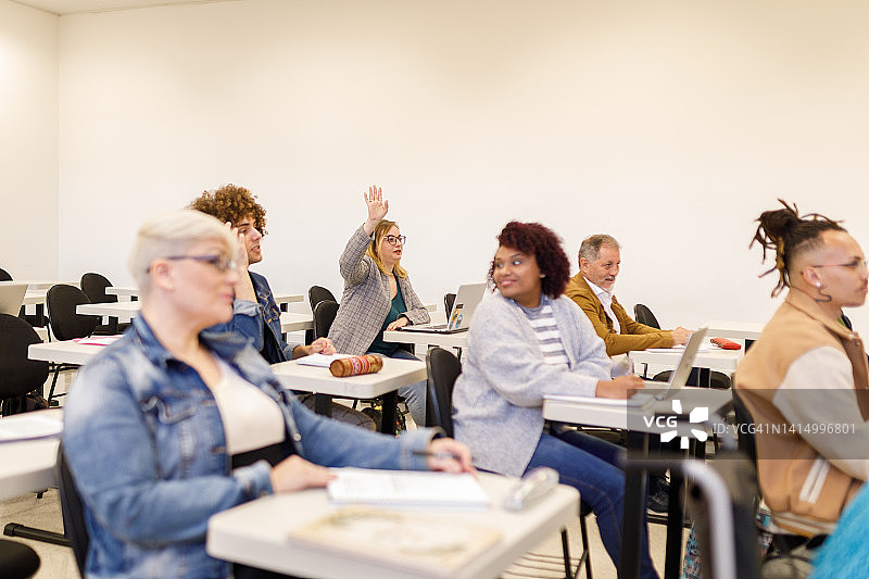 戴眼镜的女人在课堂上提问图片素材