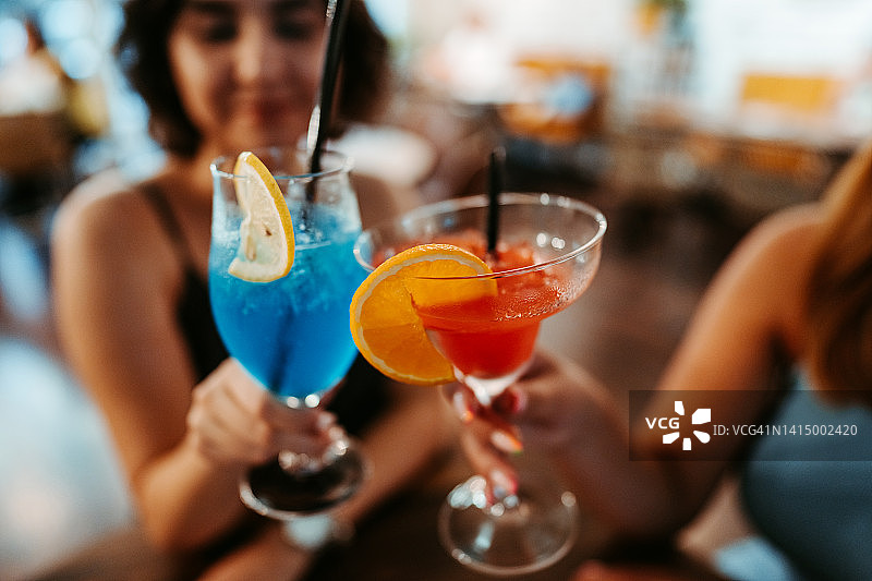 两个朋友夜晚外出享用鸡尾酒图片素材