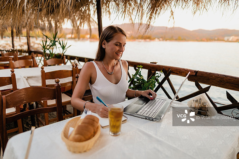 女子在海滨度假时学习和做作业图片素材