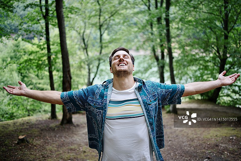 年轻男人在森林徒步时呼吸新鲜空气图片素材