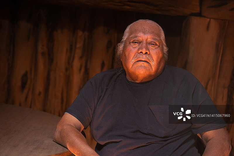 在犹他州纪念碑谷传统纳瓦霍霍根中的年长土著纳瓦霍男人肖像图片素材