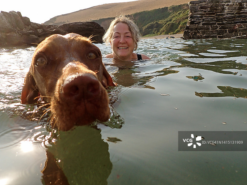 女人和狗一起游泳图片素材