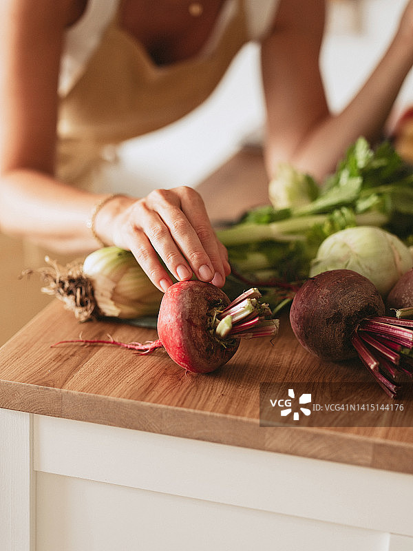 女人手拿甜菜根和新鲜收获的蔬菜图片素材