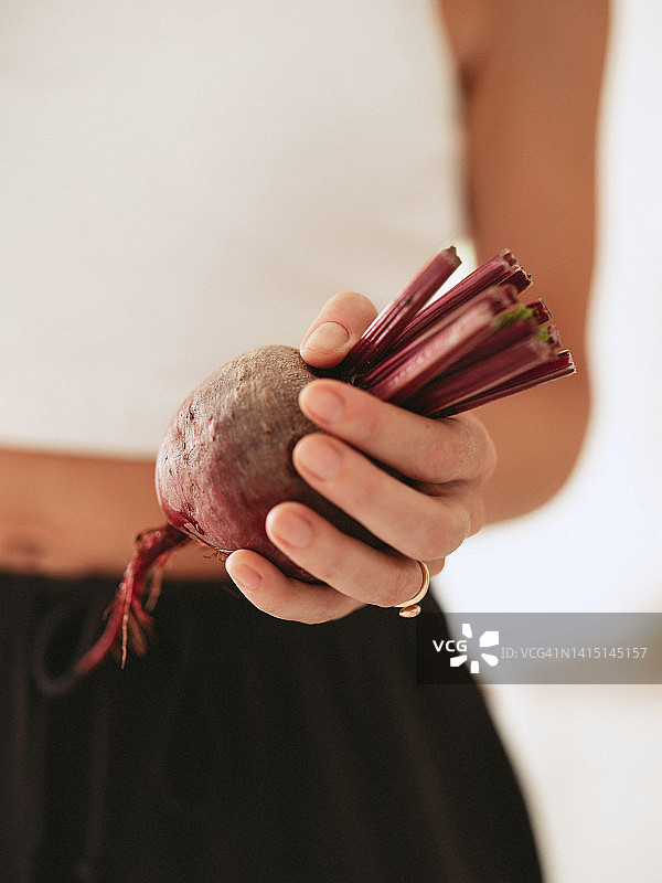女人手拿甜菜根和新鲜收获的蔬菜图片素材