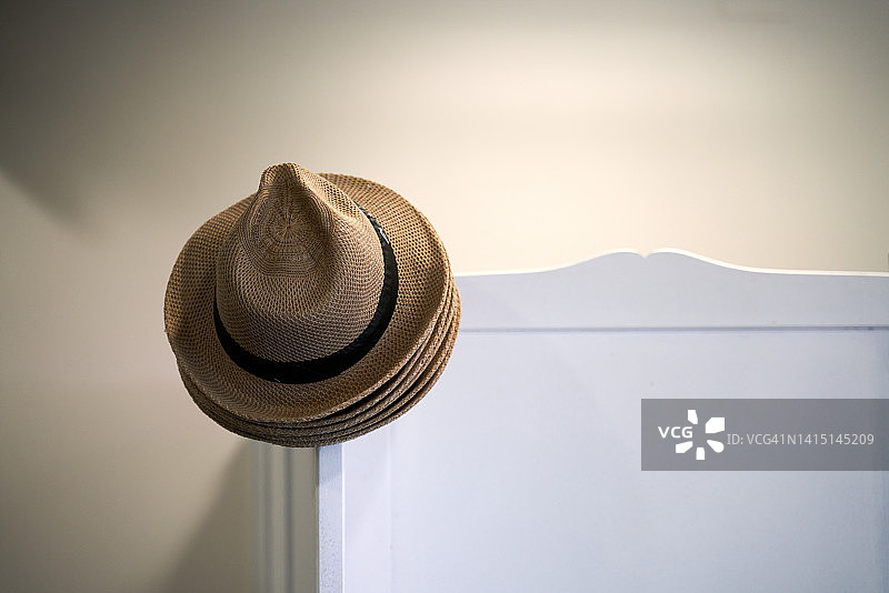挂在家具角落的许多草帽图片素材