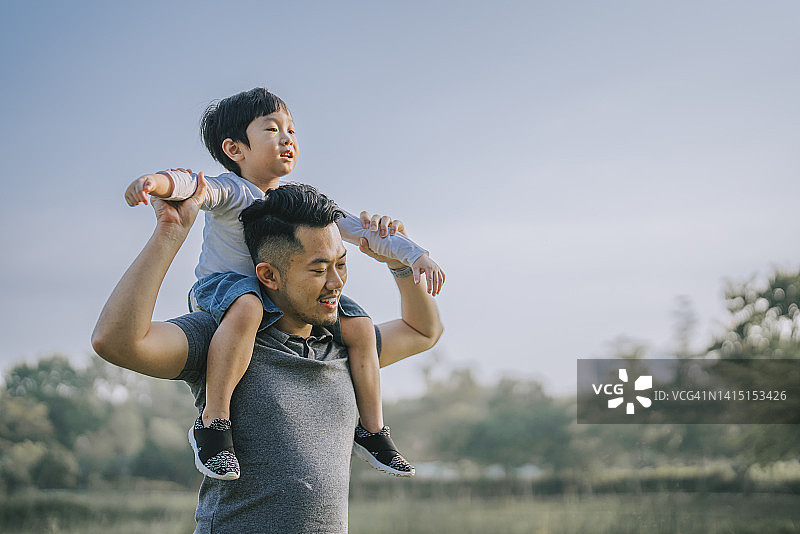 中国父亲在公园里肩扛儿子享受亲子时光图片素材