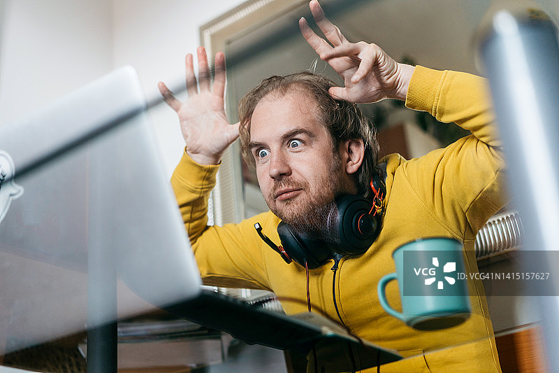 一位中年男子坐在厨房的玻璃桌旁图片素材