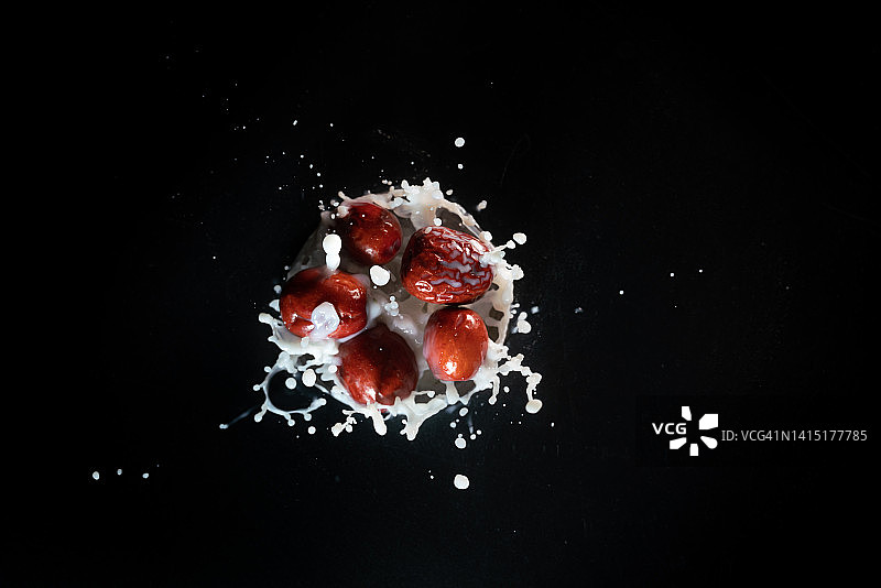 红枣牛奶飞溅黑色背景图片素材