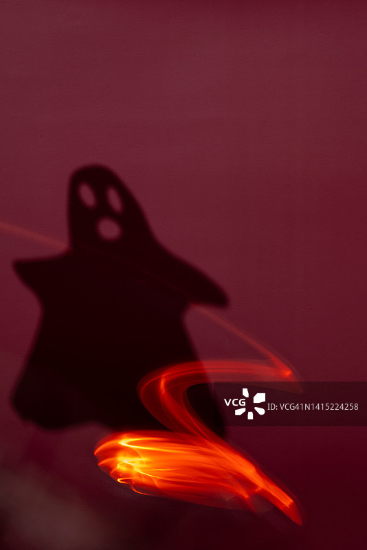 幽灵轮廓背景。黑暗万圣节背景。神秘的灵魂和红色长曝光灯光设计元素。恐怖和恐惧阴影概念。照亮的凶兆超自然符号。垂直构图，有文案空间图片素材