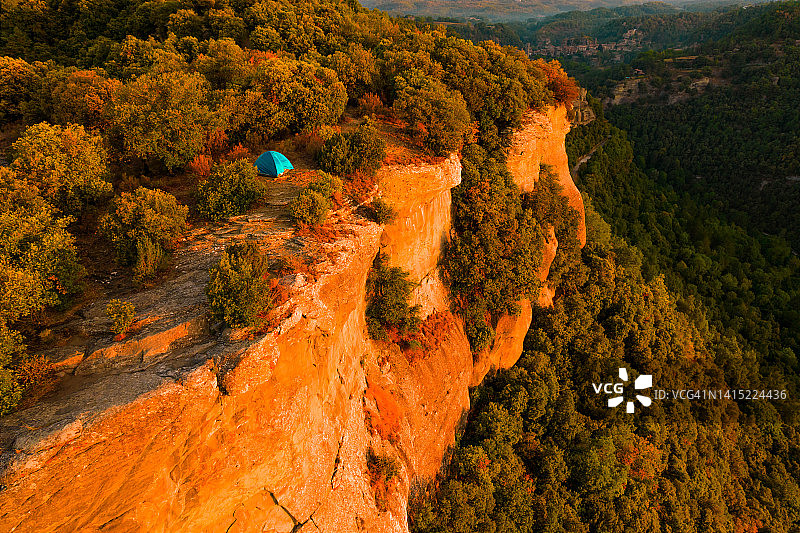 无人机视角：加泰罗尼亚鲁皮特小镇岩石峭壁旁的蓝色帐篷图片素材