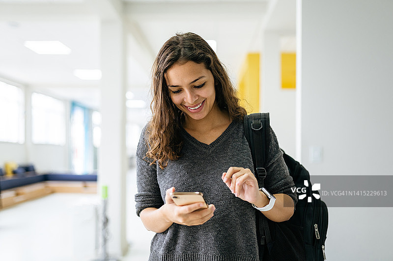 年轻女人在大学使用智能手机图片素材