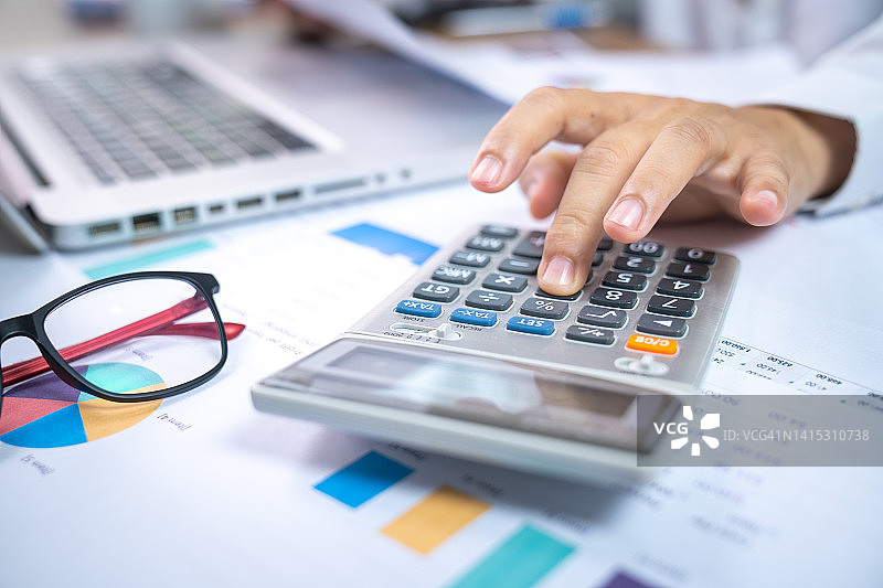 在办公桌上进行财务会计计算的商人图片素材