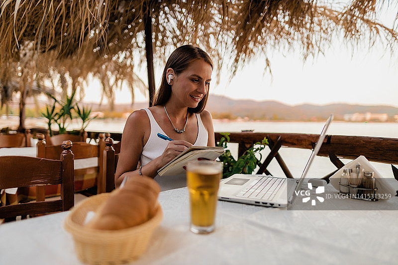 年轻女人在希腊度假期间上网课图片素材